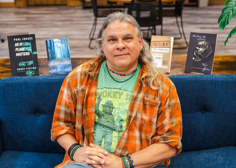 In this photo, Seminole State College Assistant Professor of English Paul Juhasz is pictured along with a collection of his published books.