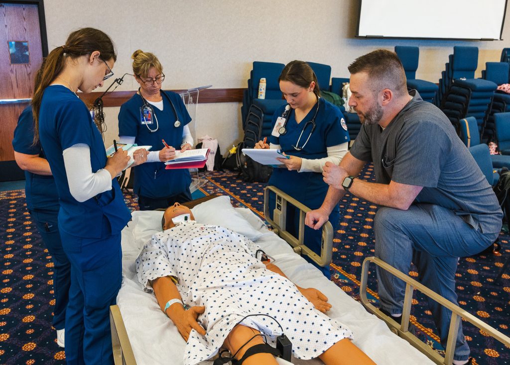 In this photo, Assistant Professor of Nursing Butch Cantrell, assists several Seminole State College nursing students during a simulation training event on March 25. 