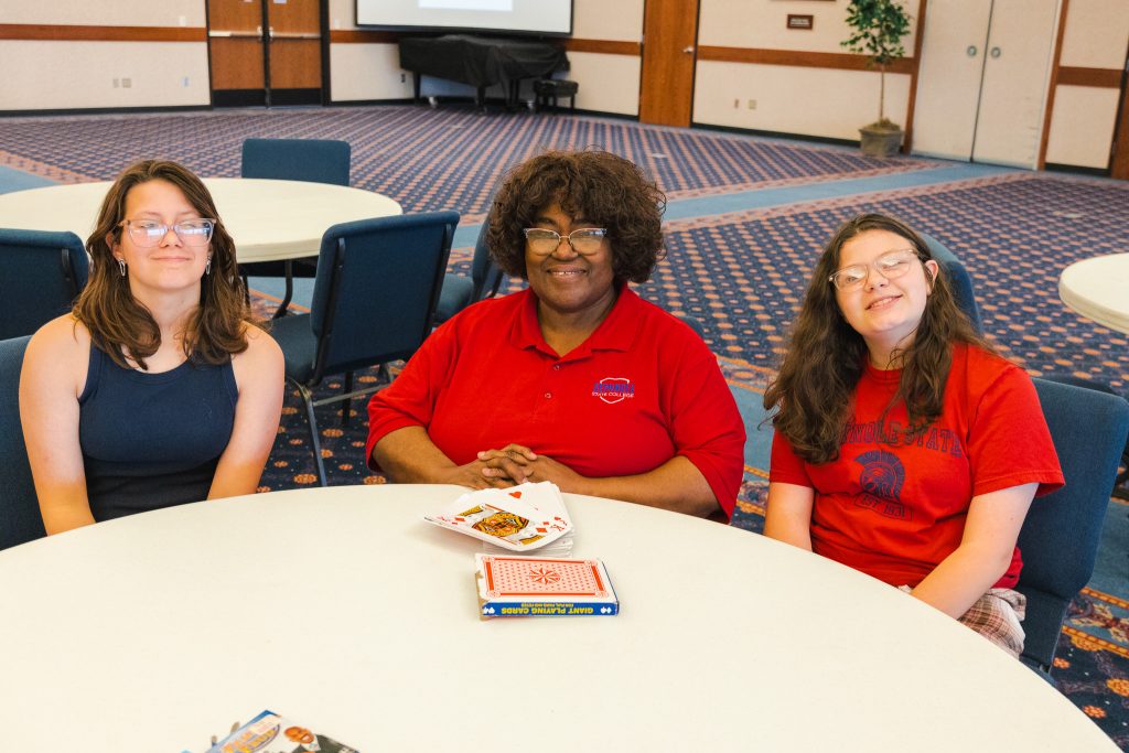 In this photo, Strother Middle School students Aubree Fleming (left) and Cara Fleming (right) play a card game with GEAR UP Educational Coordinator Jackie Bush (center) during the event.