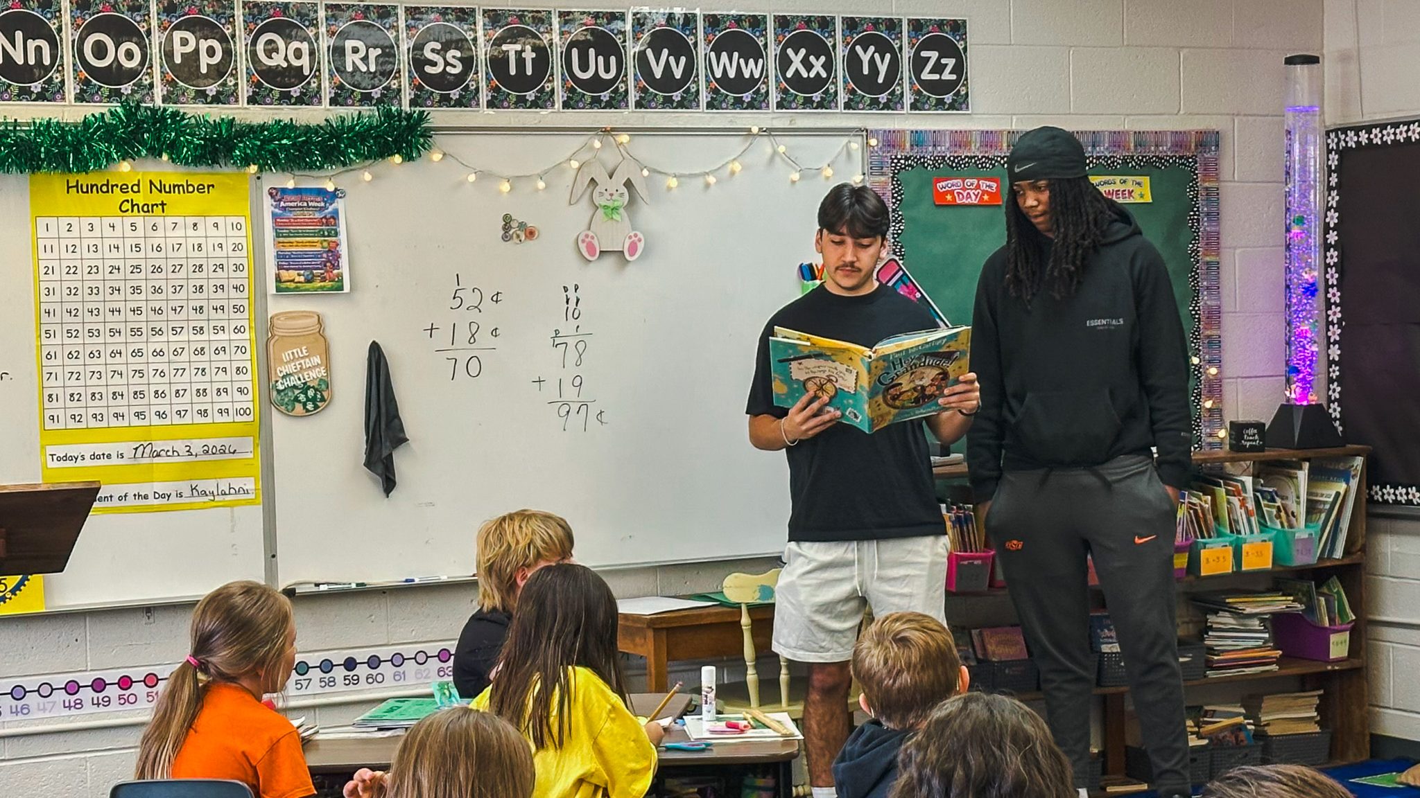 In this photo, SSC freshmen and members of the men’s basketball team Kanaan Guerrero of Cushing and Jaden Johnson of Tulsa read Hey Grandude by Paul McCartney to Wilson Elementary students on March 3.