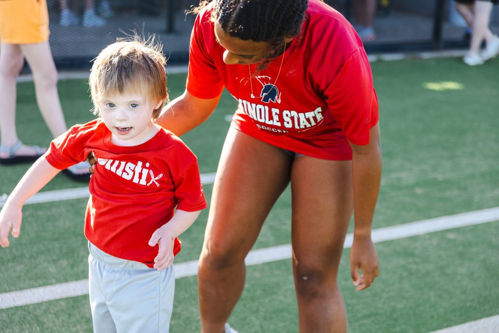 In this photo, SSC soccer player Jillian Powell congratulates A League of Their Own player Gatlin Garner after he gets a first-base hit.