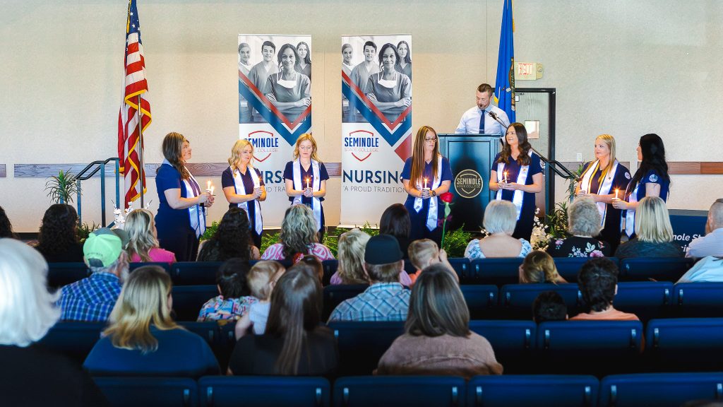 In this photo, Seminole State College Nursing graduates participate in a candle lighting during their pinning ceremony.