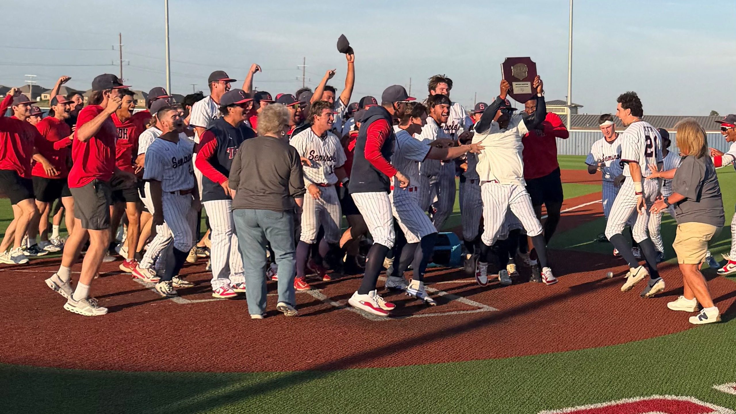 In this photo, the Seminole State College baseball team celebrate on the field as head coach Mack Chambers hoists the NJCAA Division 1 District Championship trophy.