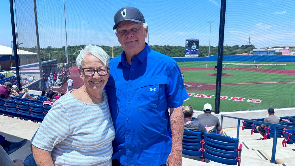 In this photo, former Trojans Baseball Coach Lloyd Simmons visits with former employee Judy James at Thursday’s baseball games.