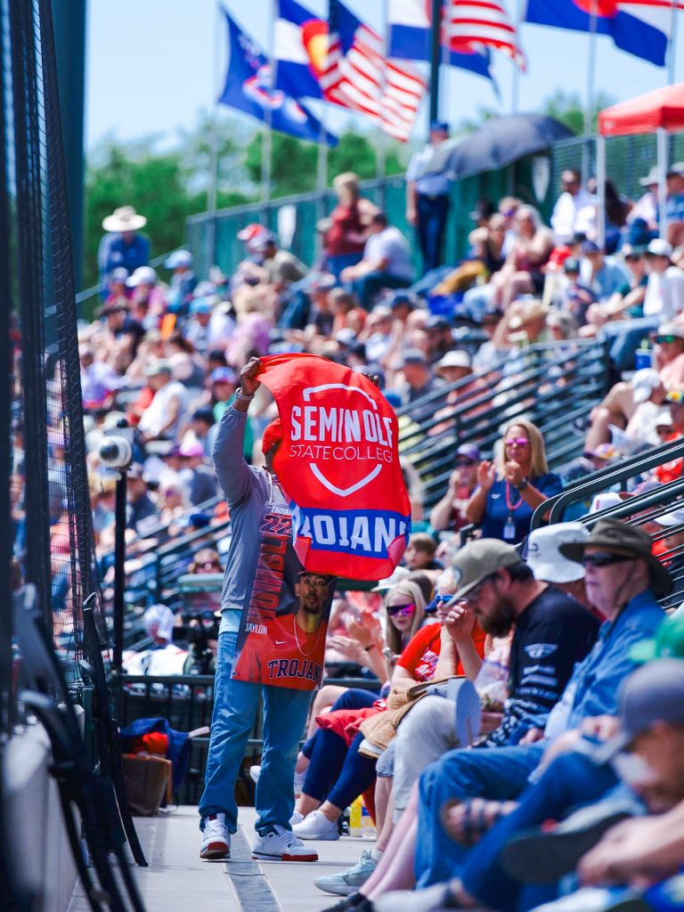 In this photo, Shelby Humbles, father of Trojan Jaylon Humbles, excites the crowd while waving the Seminole State College flag during the JUCO World Series.