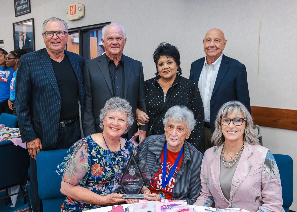 In this photo, pictured (standing, left to right) former Vice President for Student Affairs Dr. Brad Walck, former Trojan Baseball Coach Lloyd Simmons, former counselor Cynthia Yerby, former Athletic Director Dr. Thurman Edwards; and (seated left to right) former 1976 Belles Basketball player and 2026 Alumni Hall of Fame inductee Carole Carter, former Belles Coach Dixie Woodall and current Belles Coach Rita Story-Schell.