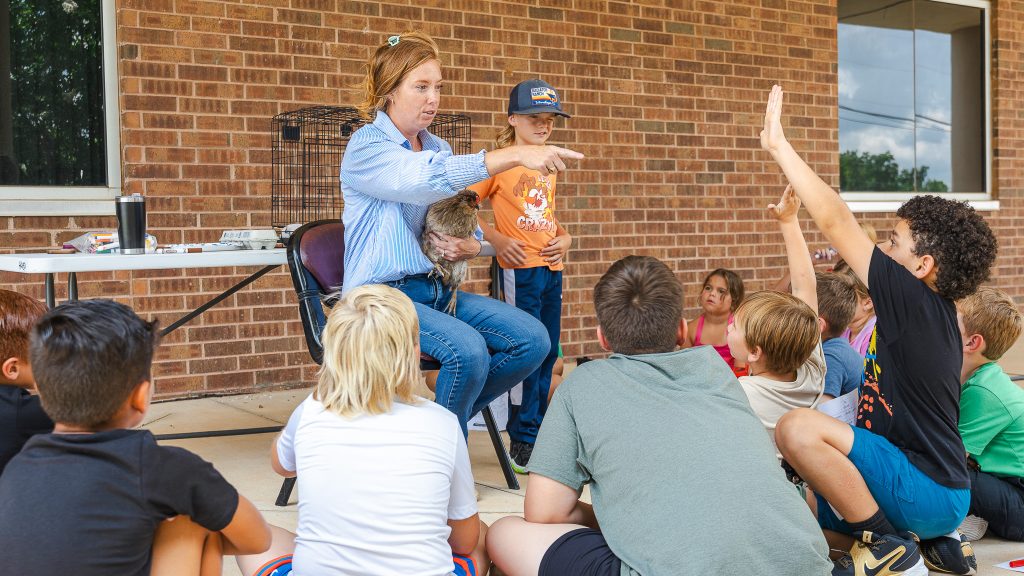 In this photo, SSC Associate Professor of Agriculture Wendy Rich holds a chicken while taking questions from Kids on Campus attendees.