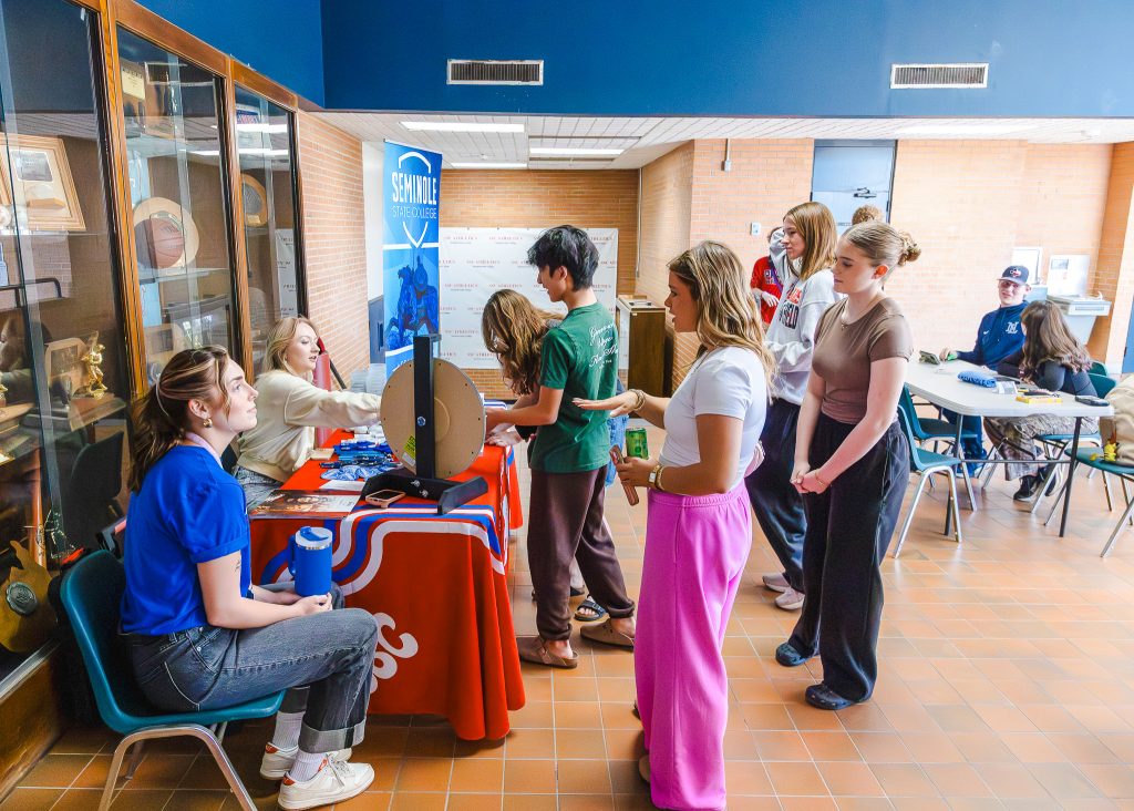 Students gather around an information table inside Seminole State College.