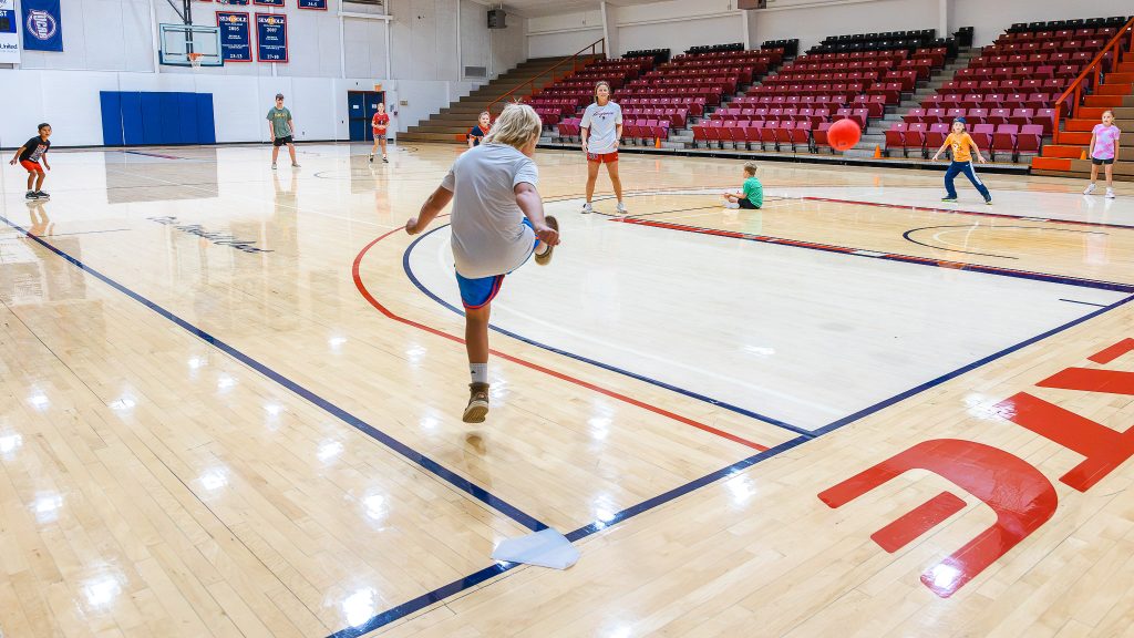 In this photo, SSC Head Volleyball Coach Bobbi Leitha leads the Wild Child Fitness Camp in a game of kickball.