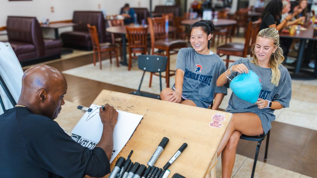 In this photo, Artist John Whitefield creates a caricature of SSC students Anna Li of Frisco, Texas, and Madelyn Jones of Wylie, Texas, on Aug. 19. SSC Student Activities and Events hosted free caricatures and cotton candy for students throughout the day.