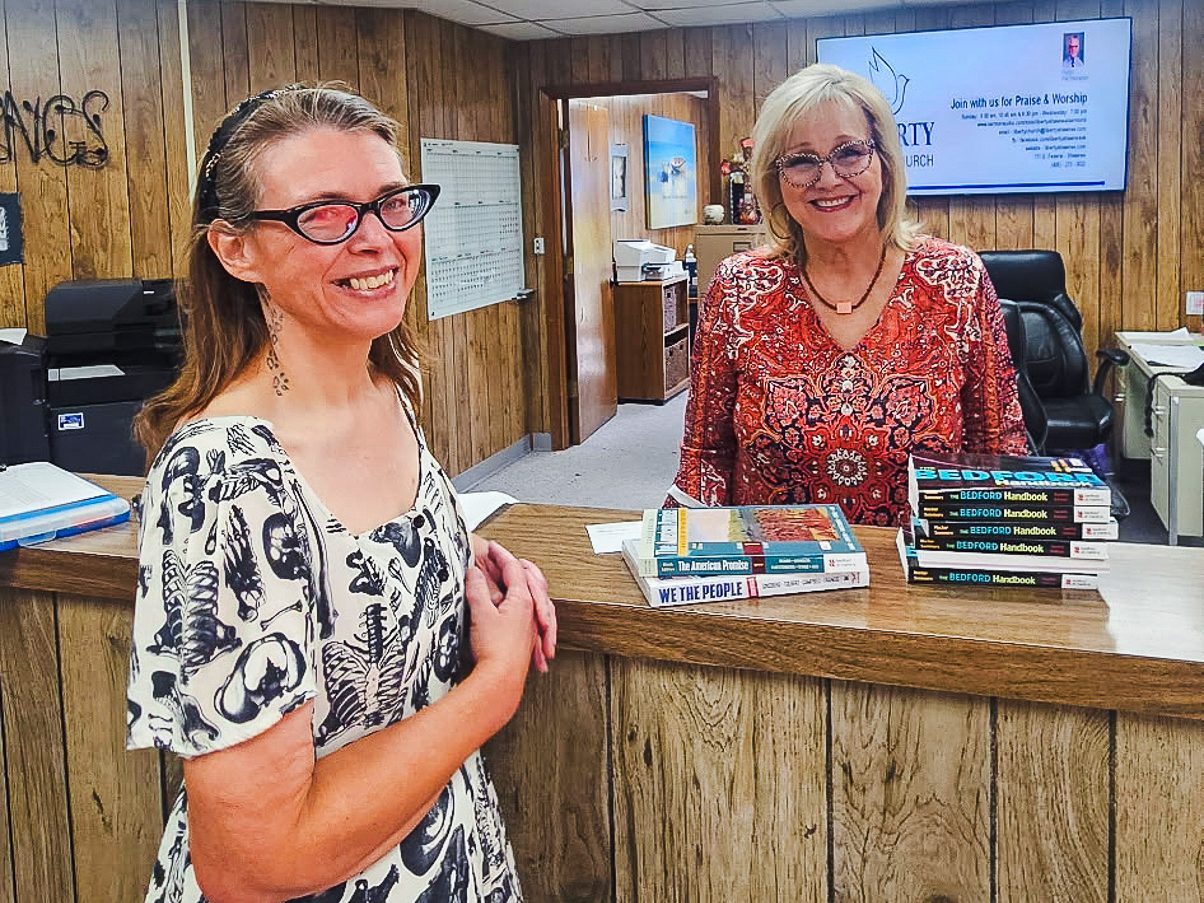 In this photo, SSC Talent Search Advisor Amanda Thomas (left) delivers textbooks to Liberty Academy Registrar Melody Licklider.