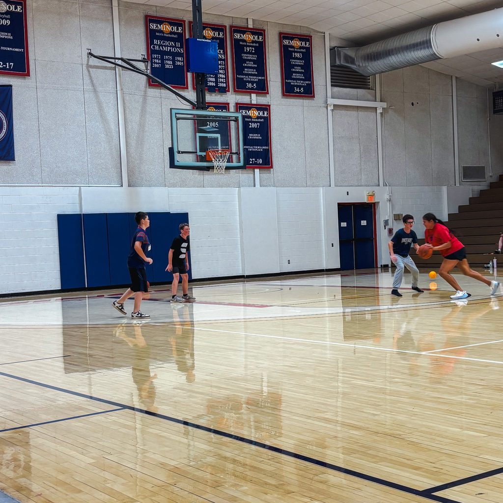 Hailey Mack plays basketball with GEAR UP students in Seminole State College’s Raymond Harber Field House during a summer 2026 camp. A former GEAR UP participant and SSC basketball player, Mack has worked at the program’s camps for the past two summers.