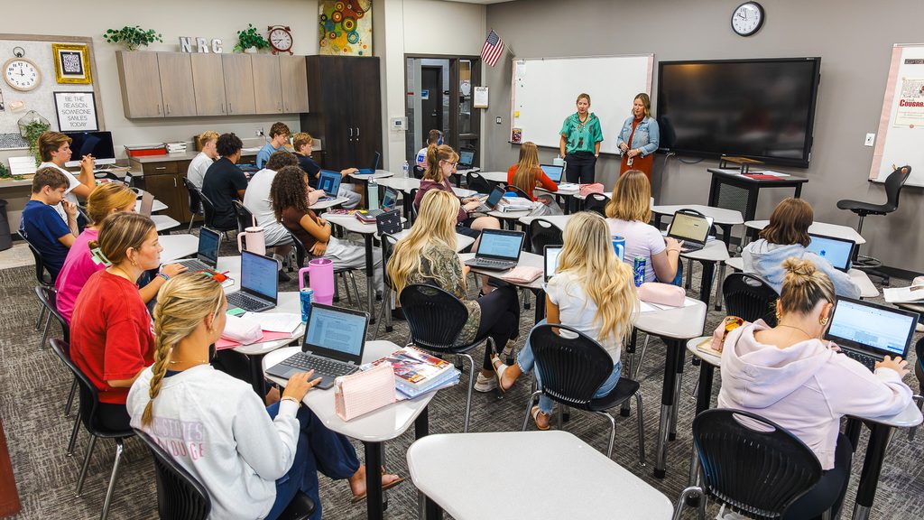 In this photo, North Rock Creek High School counselors Ashley Moody, left, and Jennifer Barnett stand at the front of the school’s dedicated concurrent enrollment classroom as students work on online Seminole State College courses.