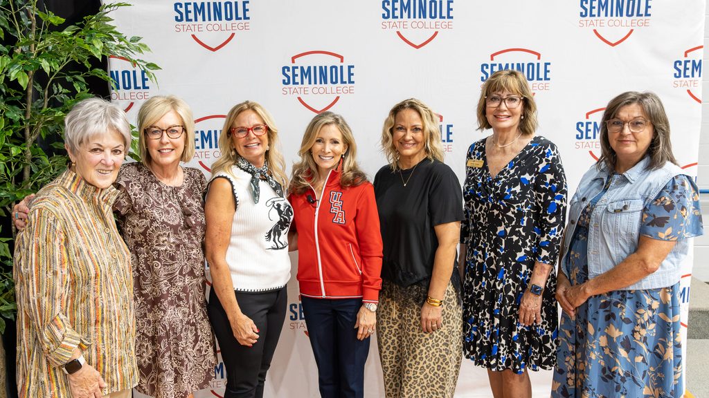 In this photo, Shannon Miller is joined by current and former Seminole State College Regents and community leaders for a group photo in front of an SSC banner. Pictured from left are former SSC Regents Marci Donaho and Kim Hyden; SSC Regent Robyn Ready; Miller; SSC Regent Haley Coates; Avedis Foundation President and CEO Dr. Kathy Laster; and SSC Regent Teresa Burnett.